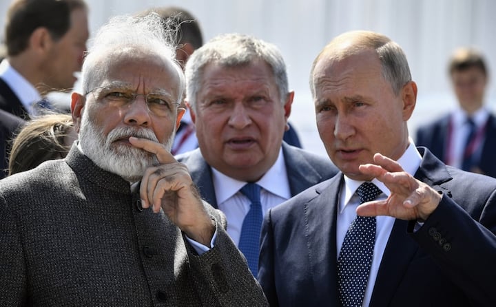 Putin speaks with PM Modi during a visit to the shipyard Zvezda, as Rosneft Russian oil giant chief Igor Sechin (C) accompanies them, outside the far-eastern Russian port of Vladivostok on September 4, 2019, ahead of the start of the Eastern Economic Forum hosted by Russia. (Photo by Alexander NEMENOV / POOL / AFP)