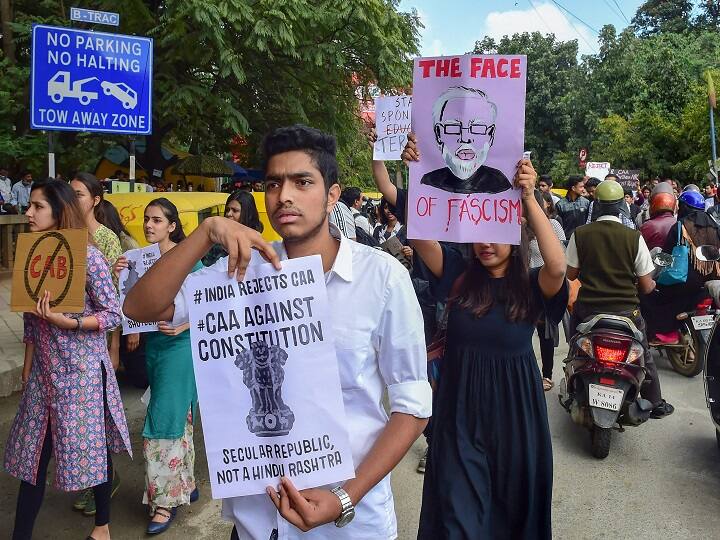 Students hold placards and raise slogans during a protest against police atrocity on students and Citizenship Amendment Act, in Bengaluru. (Image: PTI)