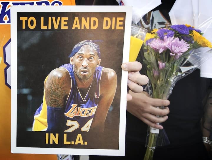Los Angeles Lakers fans hold flowers for a memorial at the scene of a helicopter crash in Calabasas on January 26, 2020. PIC/AFP.