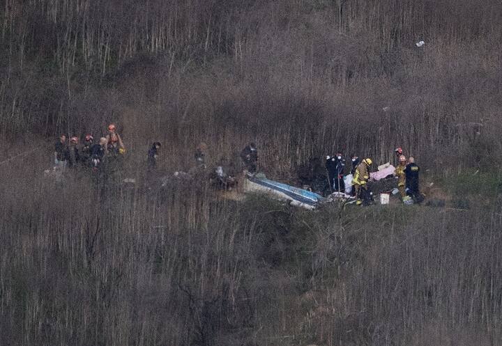 Los Angeles County Fire Department firefighters and coroner staff recover the bodies from the scene of a helicopter crash in Calabasas on January 26, 2020. - Nine people were killed in the helicopter crash which claimed the life of NBA star Kobe Bryant and his 13-year-old daughter, Gianna, Los Angeles officials confirmed on Sunday. Los Angeles County Sheriff Alex Villanueva said eight passengers and the pilot of the aircraft died in the accident. The helicopter crashed in foggy weather in the Los Angeles suburb of Calabasas. Authorities said firefighters received a call shortly at 9:47 am about the crash, which caused a brush fire on a hillside. / (Photo by Mark RALSTON / AFP)