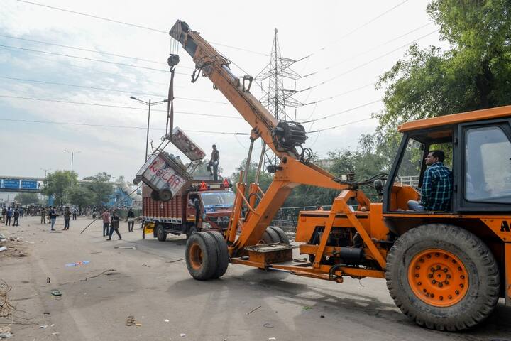 A crane is used to clean the streets in Shaheen Bagh area after removing demonstrators continuously protesting against a new citizenship law, while the government imposed a lockdown as a preventive measure against the COVID-19 novel coronavirus in New Delhi. (Photo by Sajjad HUSSAIN / AFP)