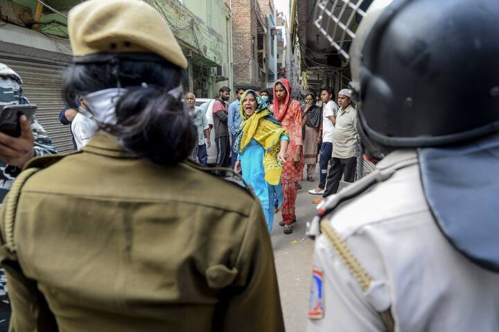 A Muslim woman (C) shouts at security personnel that patrol on the streets in Shaheen Bagh area after removing demonstrators continuously protesting against a new citizenship law, while the government imposed a lockdown as a preventive measure against the COVID-19 novel coronavirus in New Delhi on March 24, 2020. (Photo by Sajjad HUSSAIN / AFP)