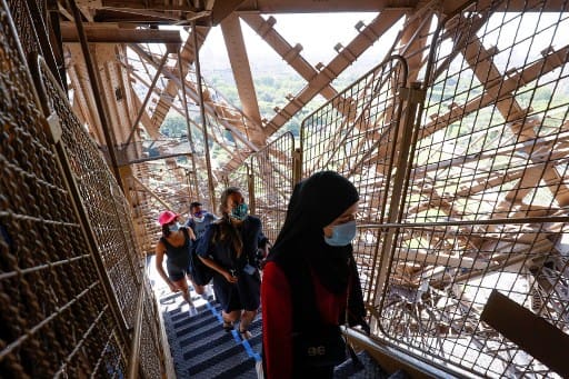 The visitors can be seen walking up the stairs at the Eiffel Tower. The French government has eased lockdown measures which it took to curb the spread of Coronavirus. (Photo by Thomas SAMSON / AFP)