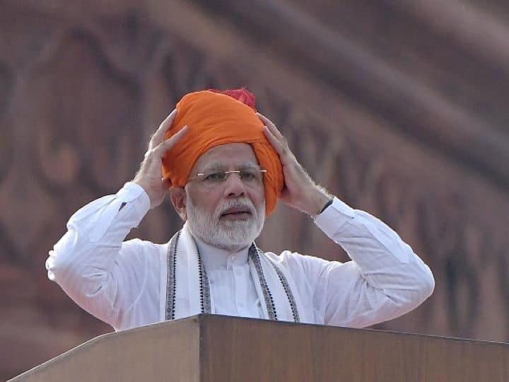 IN 2018, The largely saffron turban also had a dash of red and its long trail almost extended till the Prime Minister's ankle. The color saffron is a signifier of sacrifice and courage. The look was enhanced with his signature taut churidaar and a plain white full-sleeved kurta. This was PM Modi's fifth address and the final one of his first term as the Prime Minister. (Getty Images)