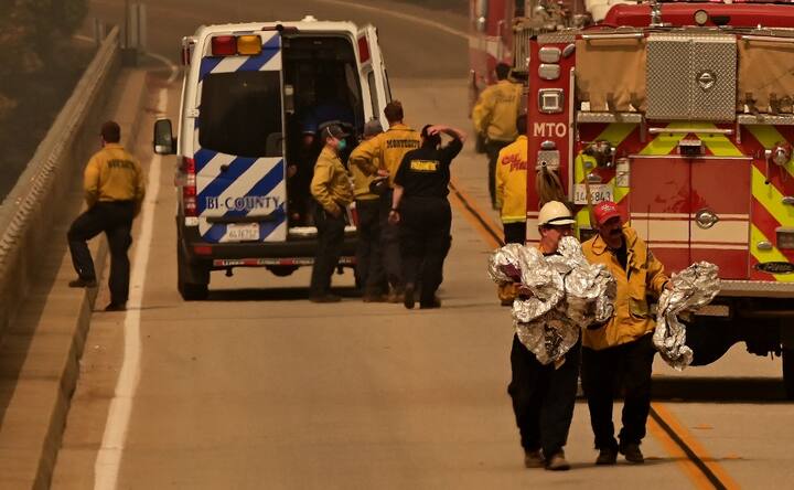 Fire personnel remove deployed fire shelters from an ambulance at a staging area for burn victims on the Enterprise Bridge during the Bear fire, part of the North Lightning Complex fires, in unincorporated Butte County in Oroville, California. The Bear fire exploded almost overnight. A report by IANS says that so far, Butte County Sheriff's Office received 85 missing person reports or requests for welfare checks.(Image AFP)