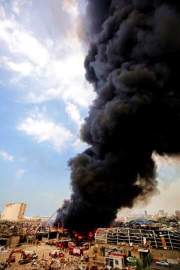 Lebanese firefighters try to put out a fire that broke out at Beirut's port area, on September 10, 2020. - Thick black columns of smoke rose into the sky, as the army said it had engulfed a warehouse storing engine oil and vehicle tyres. (Photo by ANWAR AMRO / AFP)