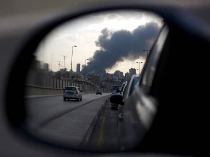 Smoke billowing from a huge fire in the Lebanese capital Beirut's seaport appears in the rear-view mirror of a car as it drives along a nearby road, on September 10, 2020. (Photo by PATRICK BAZ / AFP)