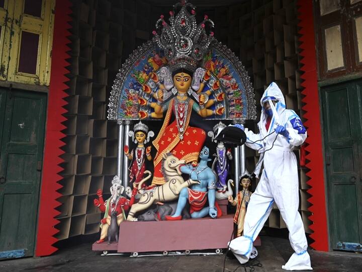 A man in a personal protective equipment (PPE) suit sanitises an idol of the Hindu goddess Durga ahead of the upcoming 'Durga Puja' festival, in Kolkata. Dibyangshu SARKAR / AFP