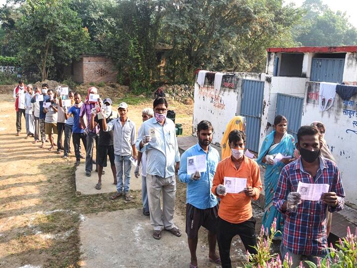 Patna: Voters show their identity cards as they stand in a queue outside a polling station to cast their votes for the first phase of Bihar Assembly Elections, at Naubatpur in Patna, Wednesday,  Oct. 28, 2020. (PTI Photo)