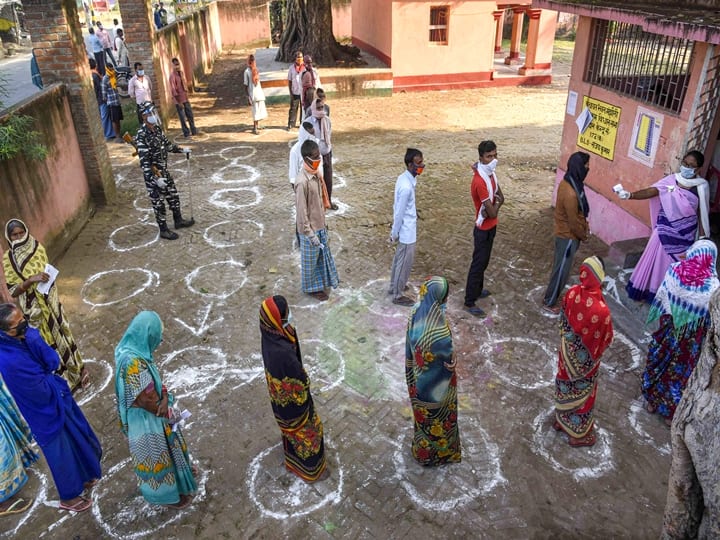 Patna: Voters, adhering to social distancing norms, stand in queues outside a polling station to cast their votes for the first phase of Bihar Assembly Elections, at Paliganj constituency in Patna, Wednesday,  Oct. 28, 2020. (PTI Photo)