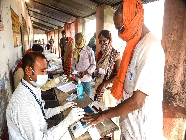 Patna: Polling officials mark the fingers of voters with indelible ink at a polling station before they cast their votes for the first phase Bihar Assembly Elections, at Naubatpur in Patna, Wednesday, Oct. 28, 2020. (PTI Photo)