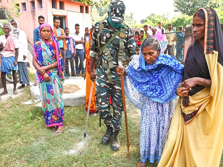 Gaya: A security official escorts an elderly woman inside a polling station as she arrives to cast her vote for the first phase of Bihar Assembly Elections, at Imamganj in Gaya district, Wednesday, Oct. 28, 2020. (PTI Photo)