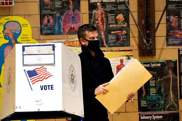 Medical diagrams hang on the wall of the gymnasium as people vote at at Public School 33 in Chelsea on Election Day, November 3, 2020 in New York City. - Americans were voting on Tuesday under the shadow of a surging coronavirus pandemic to decide whether to reelect Republican Donald Trump, one of the most polarizing presidents in US history, or send Democrat Joe Biden to the White House. (Photo by Bryan R. Smith / AFP)