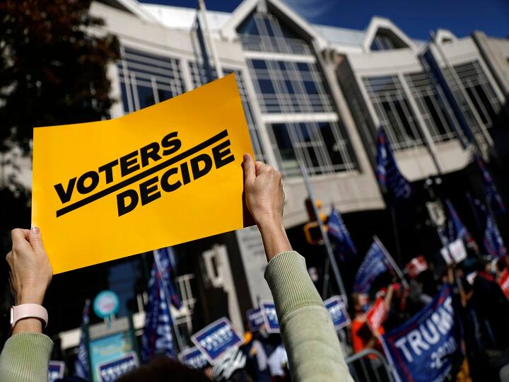 Philadelphia : A demonstrator calling for all votes to be counted holds up a sign toward protesting supporters of President Donald Trump outside the Pennsylvania Convention Center, Thursday, Nov. 5, 2020, in Philadelphia, as vote counting in the general election continues. AP/PTI (AP06-11-2020_000003A)