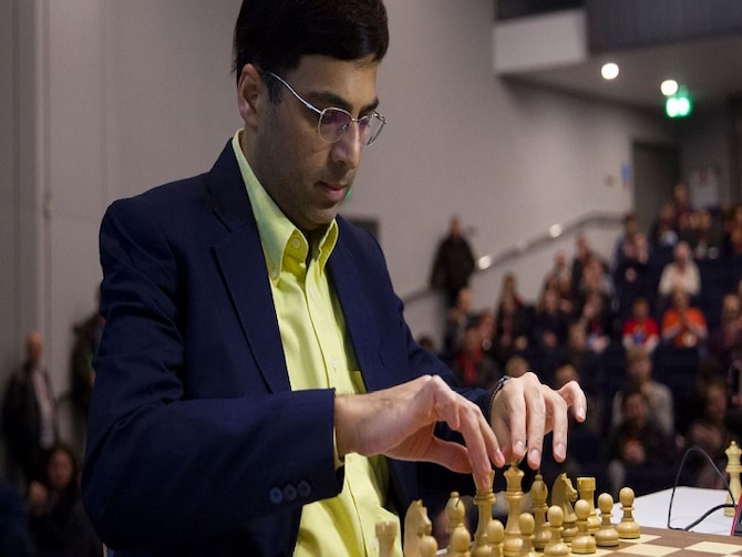 V. P. Kaushik, 11, watches as Indian World Rapid Chess Champion Viswanathan  Anand, unseen right, makes a move at the launch of a school chess  tournament organized by the NIIT Mind Champion's