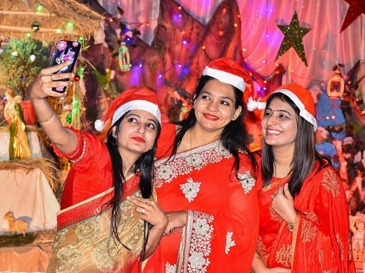 Women celebrate Christmas festival at Saint Aloysius in Jabalpur. Amid the coronavirus pandemic, the country is all set to celebrate Christmas, albeit with restricted entry to churches, live streaming of services, and no midnight Mass. (Image: PTI)