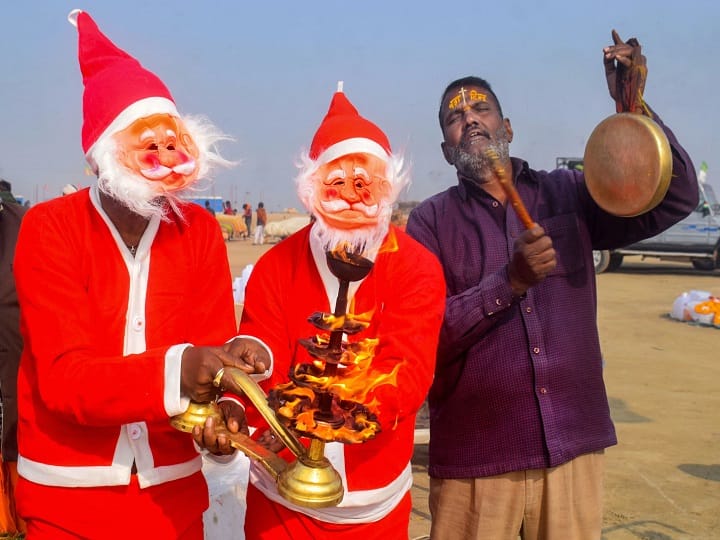Devotees dressed as Santa Claus perform 'Arti' after taking a holy dip in the Ganga, ahead of Christmas festival, at Sangam in Uttar Pradesh's Prayagraj. (Image: PTI)