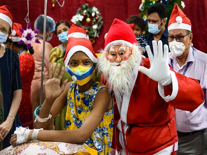 A man dressed as Santa Claus poses for photographs with a girl during Christmas celebration, at Bai Jerbai Wadia Hospital For Children in Mumbai. Maharashtra, which accounts for the highest number of coronavirus cases and has also clamped a night curfew, will also have a toned-down Christmas celebration this year. (Image: PTI)