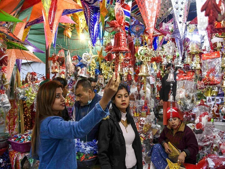 People buy decorative items ahead of the Christmas festival, in Guwahati. In a bid to curb further rise in COVID-19 cases in Assam, the State Government has imposed restrictions on Christmas and New Year celebration nights. (Image: PTI)