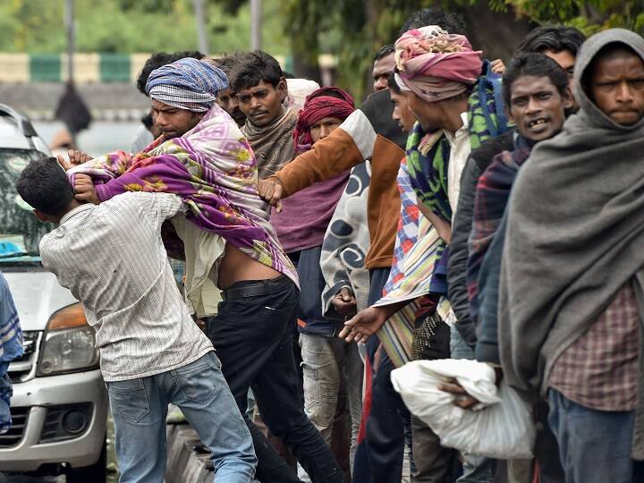Two men engage in a scuffle as other daily wagers and homeless wait in a queue to receive food distributed by Delhi government during a 21-day nationwide lockdown, to contain the spread of coronavirus, near Nigam Bodh ghat in New Delhi on March 27. (Image: PTI)