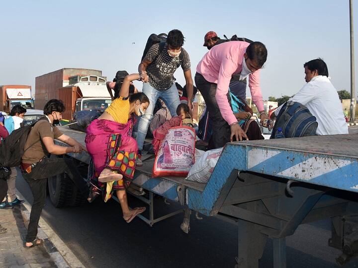 Migrants board a trailer of a truck at Gazipur on the Delhi-UP border during their journey to reach their native places, in New Delhi in May. (Image: PTI)