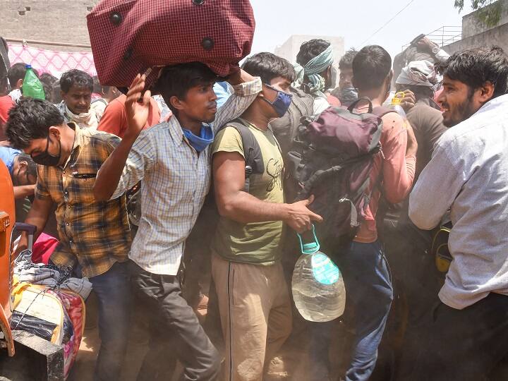 Migrant workers, lodged at a camp by the Uttar Pradesh government, rush to board a bus during ongoing COVID-19 lockdown, at Dadri in Gautam Buddha Nagar district in May. (Image: PTI)