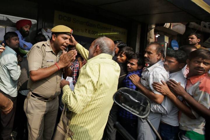बैंक के अंदर जाने की जिद कर रहे एक बुजुर्ग को समझाता पुलिस वाला.
