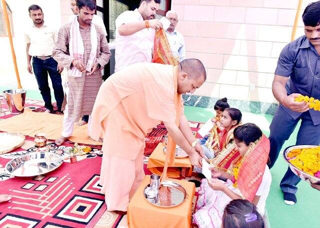 कन्या भोज के बाद कन्याओं को दक्षिणा देते सीएम योगी आदित्यनाथ