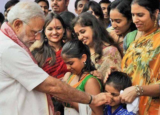 नाक पकड़कर बच्ची को दुलारते मोदी.