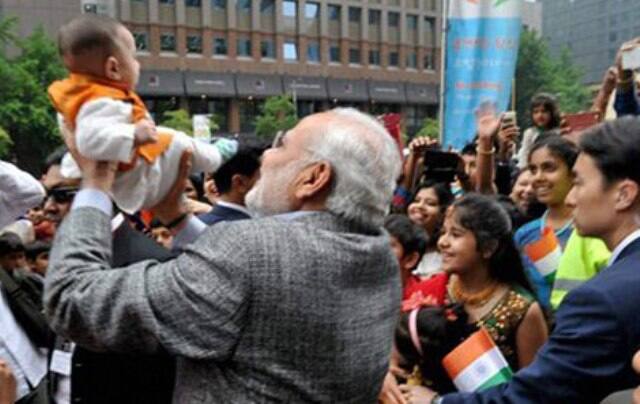 साउथ कोरिया में बच्चे को गोद में उठाकर दुलारते प्रधानमंत्री मोदी.
