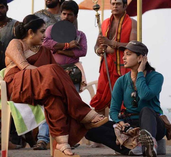 शिवगामी और देवसेना की ये तस्वीर देखिए कितनी दिलचस्प है. इसमें शिवगामी अपने कॉस्टयूम में बैठी हैं तो वहीं अनुष्का उनके साथ कुछ बातचीत करती दिख रही हैं. (Photo: Arka Mediaworks)
