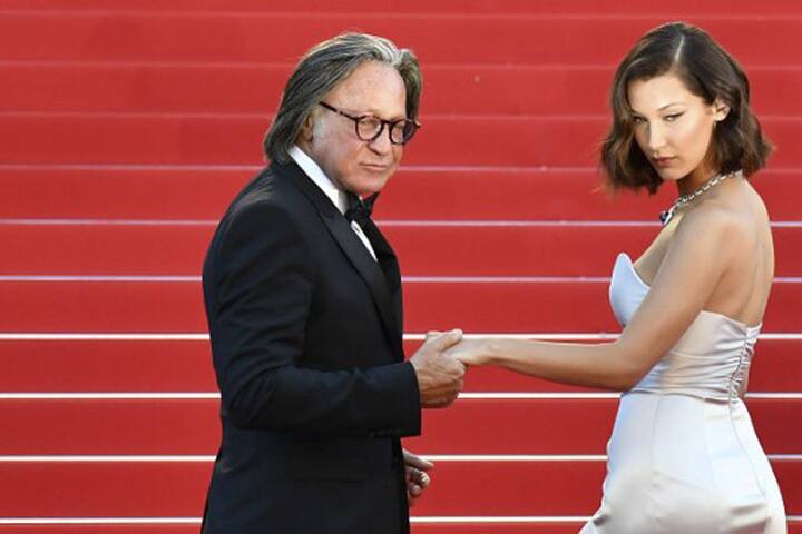 बेला हैडिय यहां पर अपने डैड के साथ रेड कार्पेट पर नज़र आईं. (Photo: AFP)