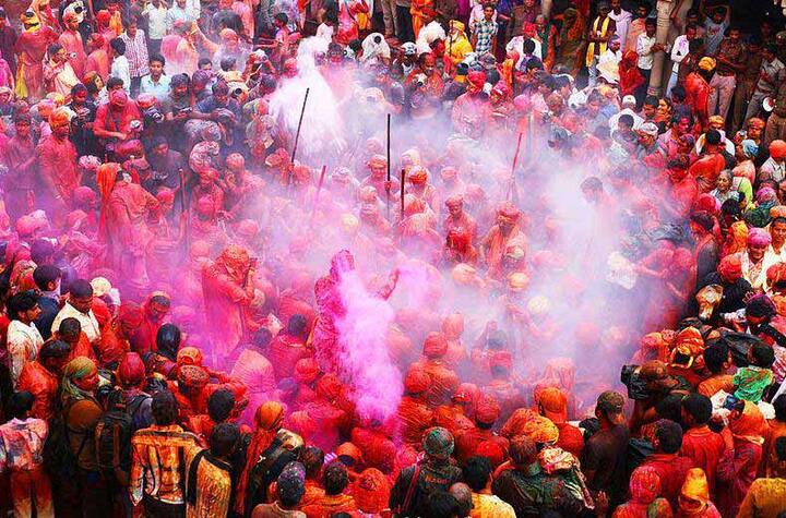लट्ठमार होली- कहा जाता है कि होली भारत के बरसाना क्षेत्र से ही शुरू हुई जिसमें वृंदावन, मथुरा, नंदगांव और बरसाना शामिल हैं. दिलचस्प बात यह है कि यहां होली न सिर्फ रंगों के साथ मनाई जाती है बल्कि लाठी के साथ खेली जाती है. परंपरा के अनुसार, महिलाएं लाठी लेकर पुरुषों का पीछा करती हैं और फिर उनकी पिटाई करती हैं. होली खेलने का ये तरीका भगवान कृष्ण के समय से चला आ रहा है. ऐसा माना जाता है कि इसी दिन कृष्ण जी अपने मित्रों के साथ मिलकर नंद गांव से बरसाना तक राधा और उनकी सहेलियों के साथ होली खेलने पहुंचे थे. बरसाना की ये लट्ठमार होली सिर्फ बरसाना में ही नहीं बल्कि पूरे देश में मशहूर है. आपको बता दें, बरसाना में आज से ही लट्ठमार होली का आयोजन होने वाला हैं जहां यूपी के सीएम योगी आदित्यलनाथ भी पहुंचने वाले हैं. 