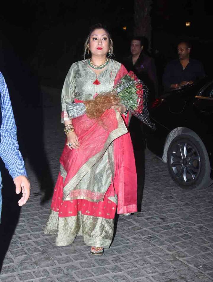 हाथ में फूलों का गुलदस्ता लिए गोविंदा की पत्नी. 