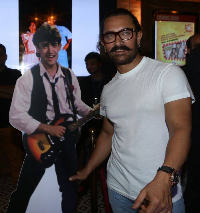 अपनी तस्वीर के साथ पोज देते आमिर. इस तस्वीर में आप साफ देख सकते हैं कि आमिर खान तीस सालों में कितने बदल गए हैं. (तस्वीर: मानव मंगलानी)