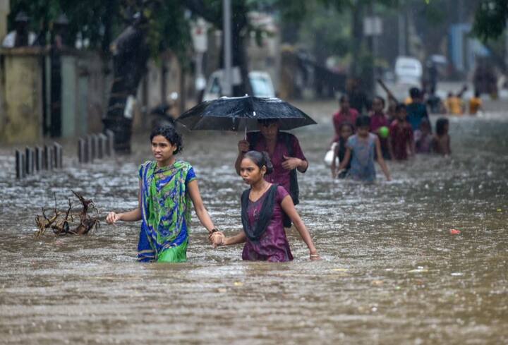 मौसम विभाग ने सोमवार तक कुछ क्षेत्रों में भारी बारिश की आशंका जताई है. ये तस्वीर सायन की है जहां बच्चों को उनकी माएं रास्ता पार करा रही हैं.