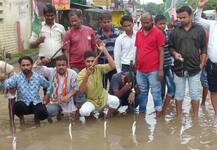 सीएम योगी की चेतावनी बेअसर, बारिश में डूबे गोरखपुर में कां‍ग्रेसियों ने सड़क पर मछली पकड़ जताया विरोध