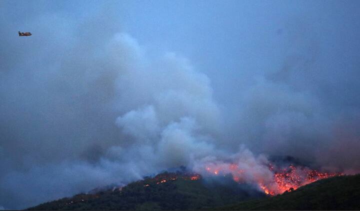 भीषण आग को बुझाने के लिए विमानों की भी मदद ली गई. (तस्वीर: एपी)