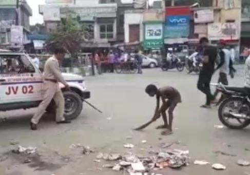 Noida: A constable captured in camera during provoke minor for brooming one road नोएडा: नाबालिग बच्चे से जबरन सड़क पर झाड़ू लगवा रहा था सिपाही, हुआ सस्पेंड