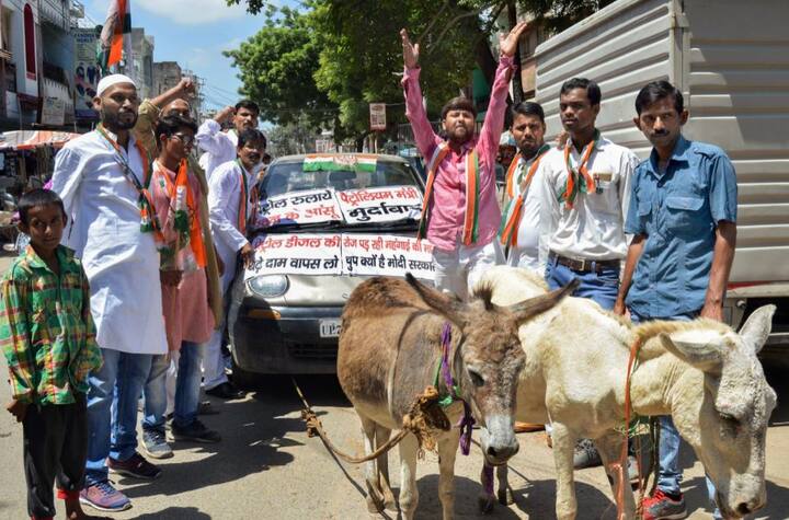  यूपी में विरोध प्रदर्शन को अनोखे तरीके से देखा गया जहां कांग्रेस कार्यकर्ता कार को गधे से बांधकर घसीटते दिखे. तस्वीर: पीटीआई 