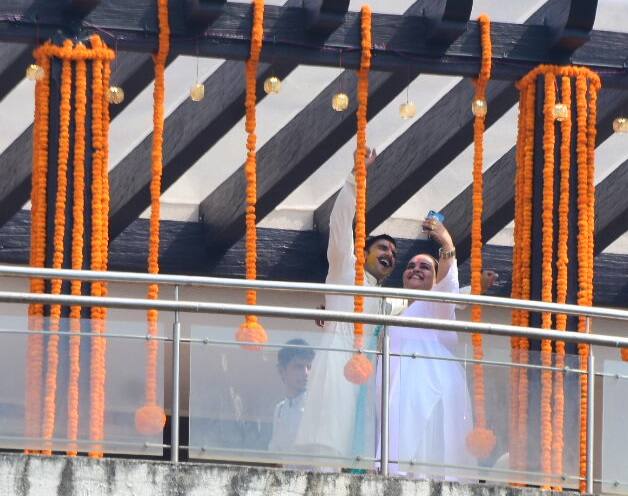  इस तस्वीरों में सफेद कुर्ते पजामा में रणवीर अपने परिवार और दोस्तों के साथ गले मिलते और सेल्फी लेते दिखाई दे रहे हैं. (तस्वीर: मानव मंगलानी) 