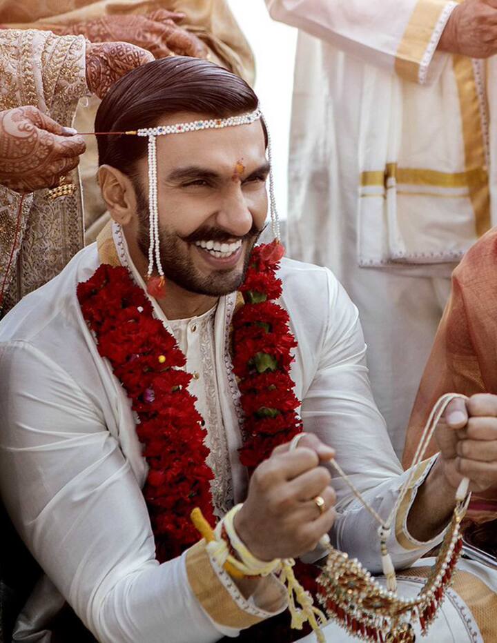 कोंकणी रिवाजों के अनुसार दूल्हा बने रणवीर सिंह ने सफेद कुर्ता और गोल्डन धोती पहनी है. वहीं, दीपिका ने इस दौरान लाल और गोल्डन रंग की ट्रेडिशनल ड्रेस पहनी है . आप रणवीर सिंह के माथे पर मुंडवली भी देख सकते हैं.