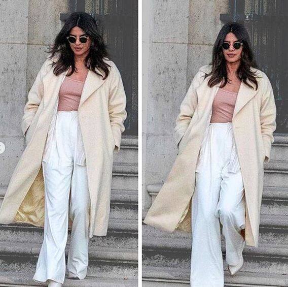  इस ट्रिप के दौरान प्रियंका लॉन्ग व्हाइट कोट, ट्राउजर और लाइट पिंक टॉप में दिखीं. फोटोः इंस्टाग्राम