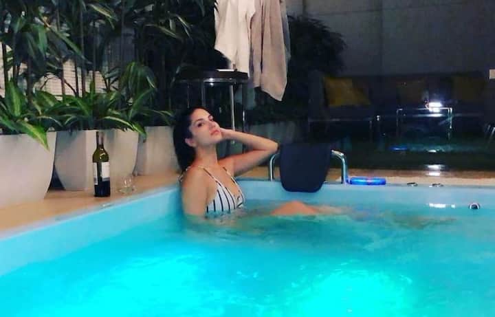 सनी लियोन ने हाल ही में एक तस्वीर शेयर की है जिसमें वो घर में बने स्विमिंग पूल में नहाती हुई दिखीं. इस दौरान उन्हें ब्लू, व्हाइट बिकिनी में देखा गया. तस्वीर: इंस्टाग्राम