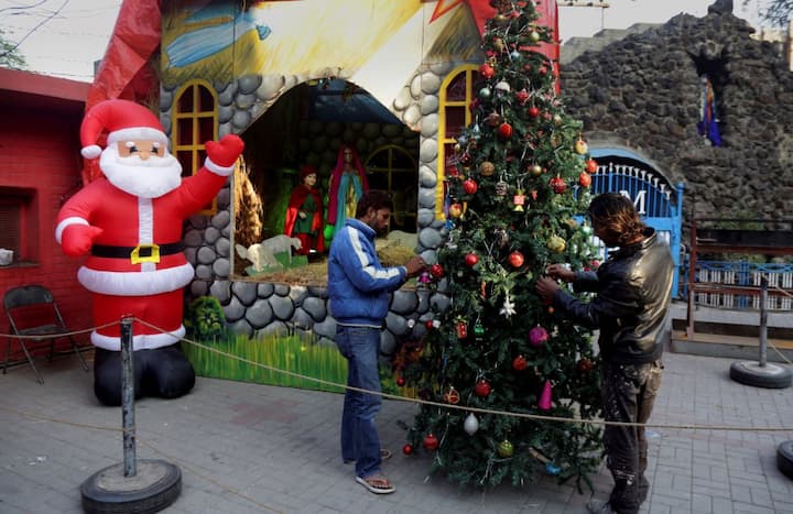 इस बीच एक तस्वीर तो पाकिस्तान से भी आई है जहां कारीगर क्रिसमस ट्री को सजाते हुए दिख रहे हैं. तस्वीर: एपी