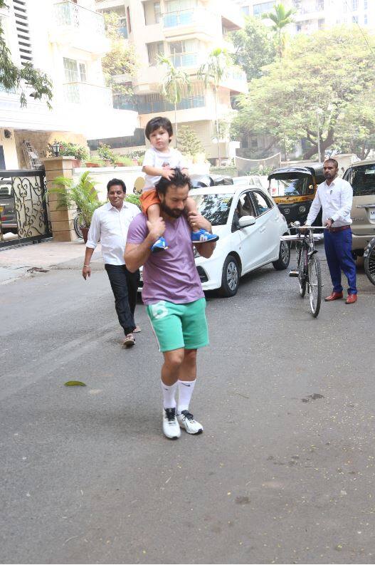 इस दौरान सैफ अली खान बेटे तैमूर के पैरों को पड़के नीची निगाहों के साथ सड़क पार करते नज़र आए. (तस्वीर: मानव मंगलानी)