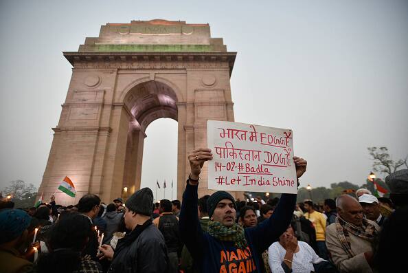 दिल्ली में इंडिया गेट पर पुलवामा जिले में हुए आतंकी हमले के खिलाफ लोग हाथों में तख्तियां, झंडे और मोमबत्तियां उठाए हुए नारेबाजी करते हुए. 