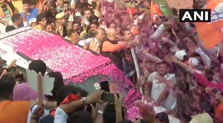 अमित शाह हाथ हिलाकर कार्यकर्ताओं का अभिवादन स्वीकार कर रहे हैं. बीजेपी दफ्तर के बाहर कार्यकर्ता हाथों में झंडे लेकर विजय उद्घोष कर रहे हैं. फोटोः एएनआई ट्विटर