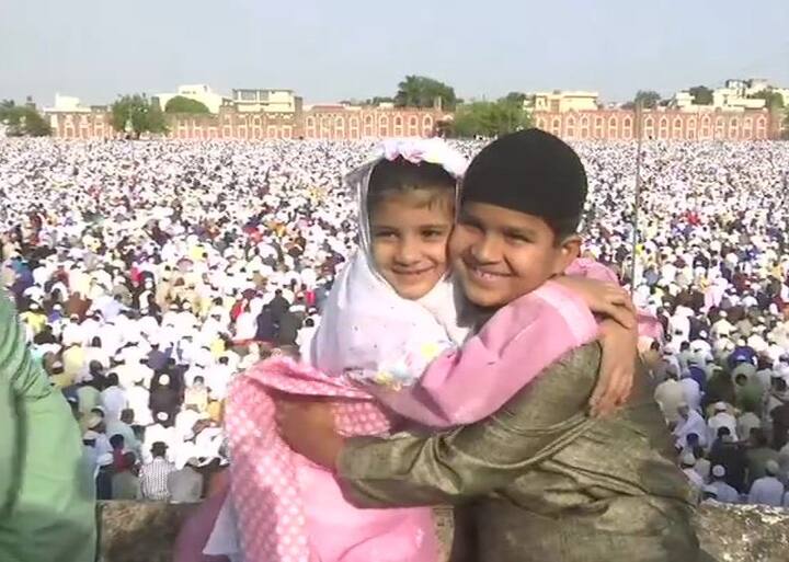 ये तस्वीर मध्य प्रदेश की राजधानी भोपाल के ईदगाह मस्जिद की है. यहां एक दूसरे को बधाई देते दोनों बच्चे. नीचे सभी लोग लाइन में बैठे हुए हैं.