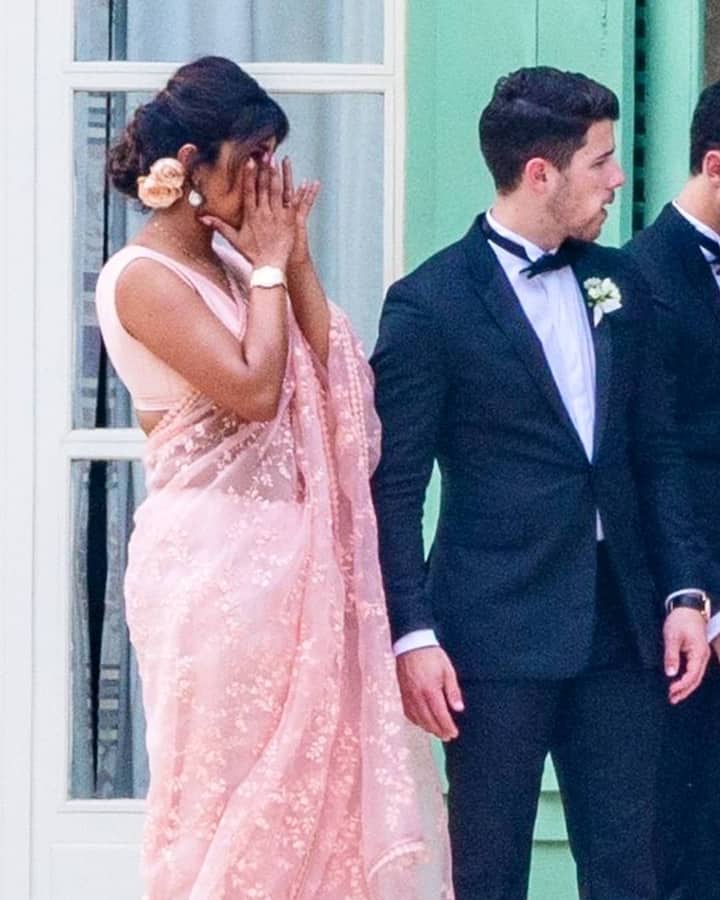 प्रियंका ने हल्के गुलाबी रंग की साड़ी के साथ हल्की ज्वेलरी पहन रखी थी और बालों का जूड़ा बनाया था. वहीं निक ने काले रंग का टक्सीडो पहन रखा था. (तस्वीर: मानव मंगलानी)